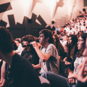 Público adolescente haciendo preguntas en un coloquio de cine.